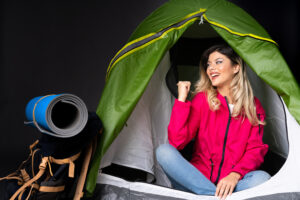 Teenager Girl Inside Camping Green Tent Black Wall Pointing Up Surprised1 300x200